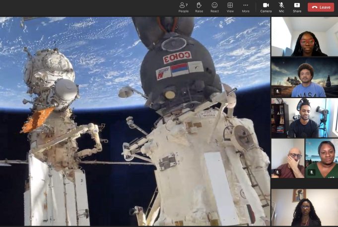 Zoom attendees looking outside the ISS at views of the structure itself, in front of the curvature of the Earth in space.