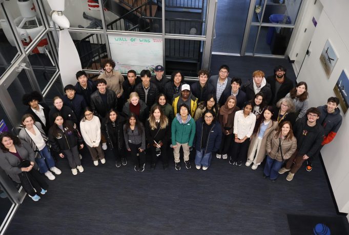 A group of people looking up at a camera indoors, with a 